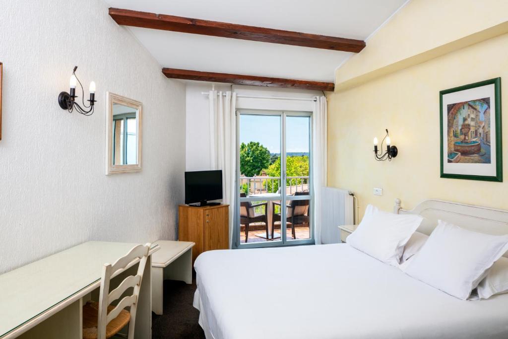 普罗旺斯艾克斯莫扎特酒店的一间卧室设有两张床、一张桌子和一个窗口。