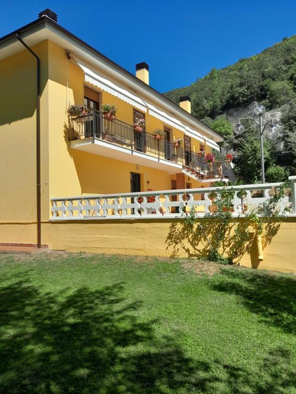皮耶迪卢科La Cannucciola的一座黄色的建筑,设有阳台,鲜花盛开