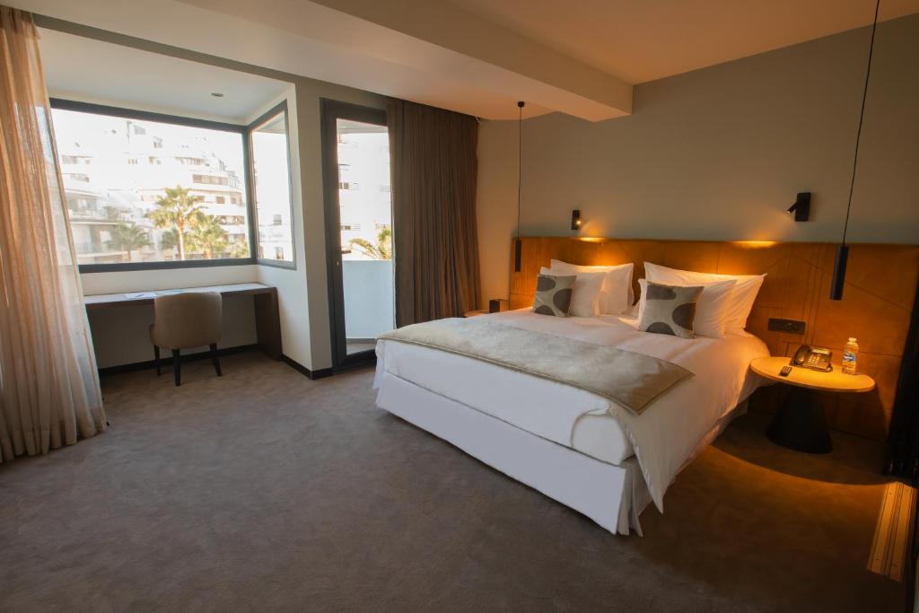 卡萨布兰卡JM Suites Hotel Eco-Friendly Casablanca的卧室设有一张白色大床和大窗户