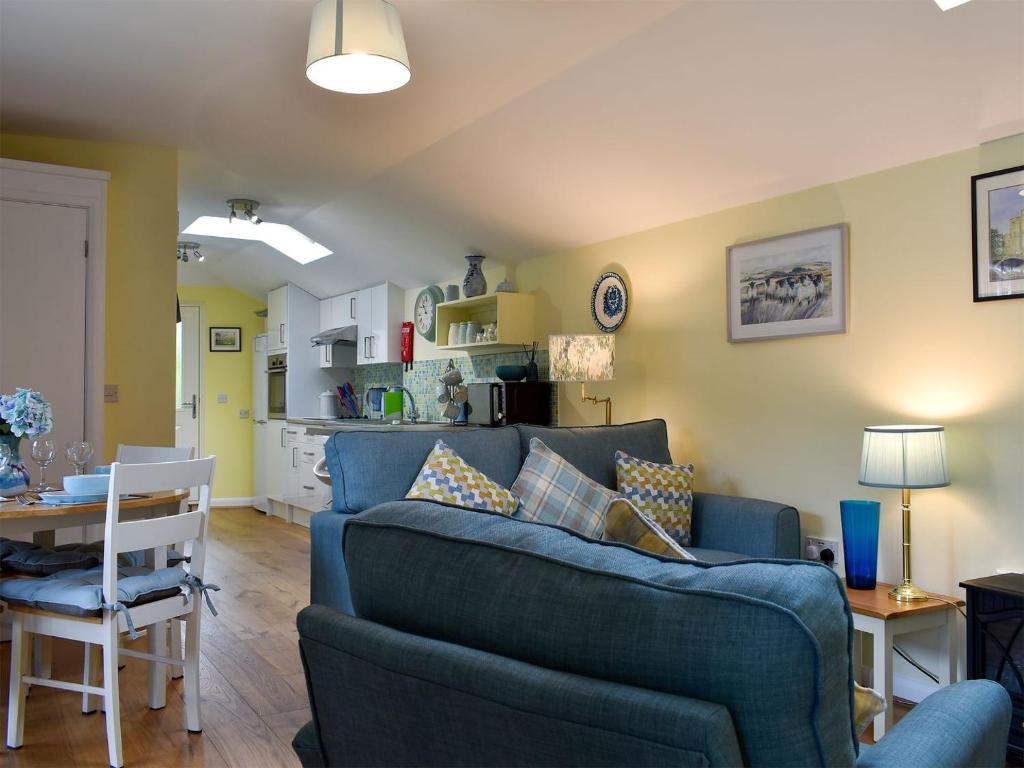BarhamThe Annexe的一间带蓝色沙发的客厅和一间厨房