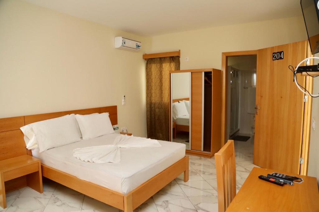 圣菲利佩Cruzeiro Guest House的一间卧室配有一张床、一张桌子和一面镜子