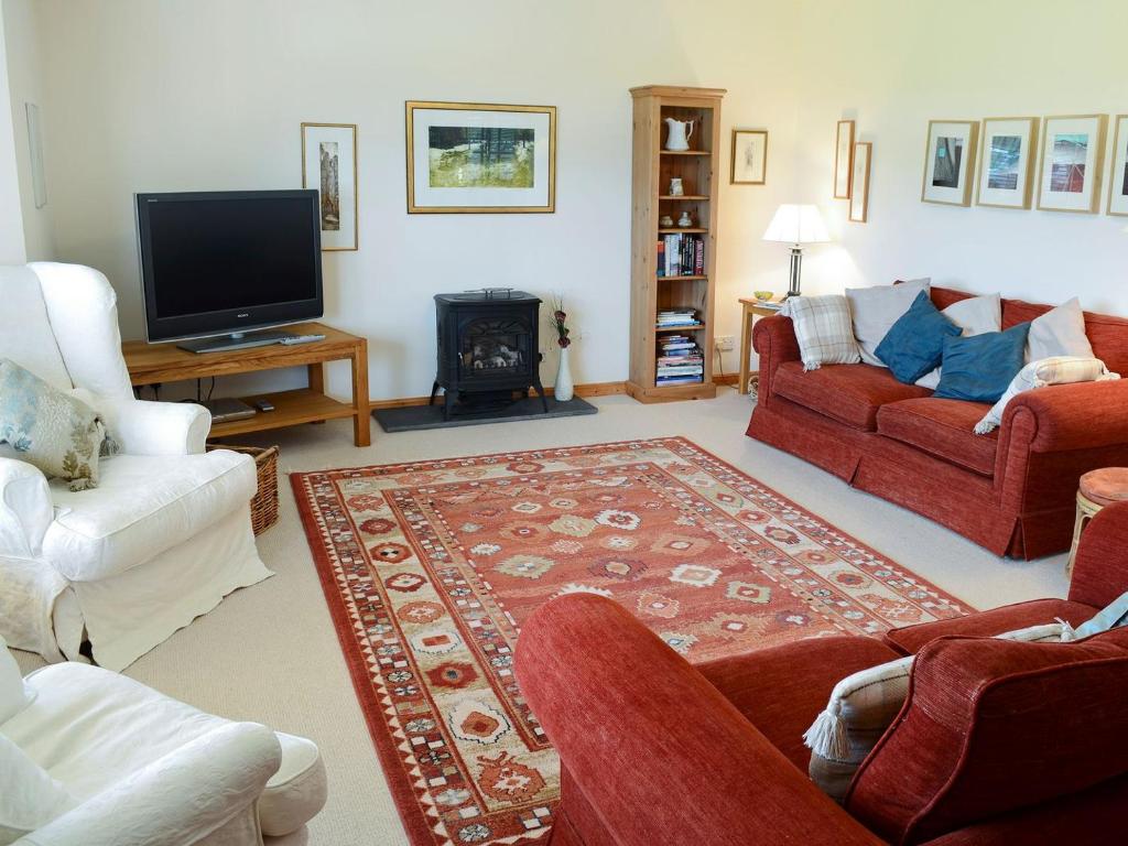 阿克格里尔Fairfield的客厅配有红色沙发和电视