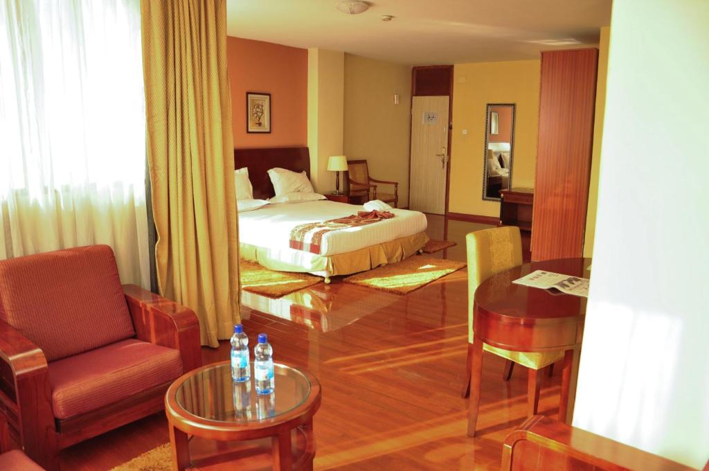 亚的斯亚贝巴丘吉尔亚的斯亚贝巴酒店的配有床、椅子和桌子的酒店客房