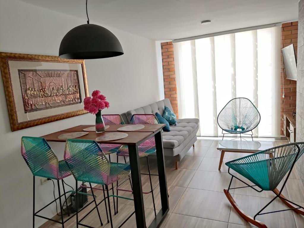 圣希尔Hermoso y Cómodo Apartamento--Excelente Ubicación的客厅配有桌椅和沙发