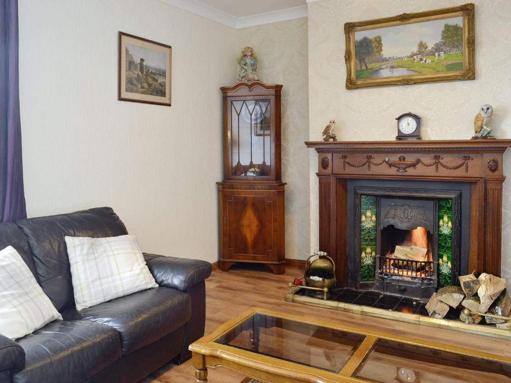 UplawmoorOld Stable Cottage的带沙发和壁炉的客厅