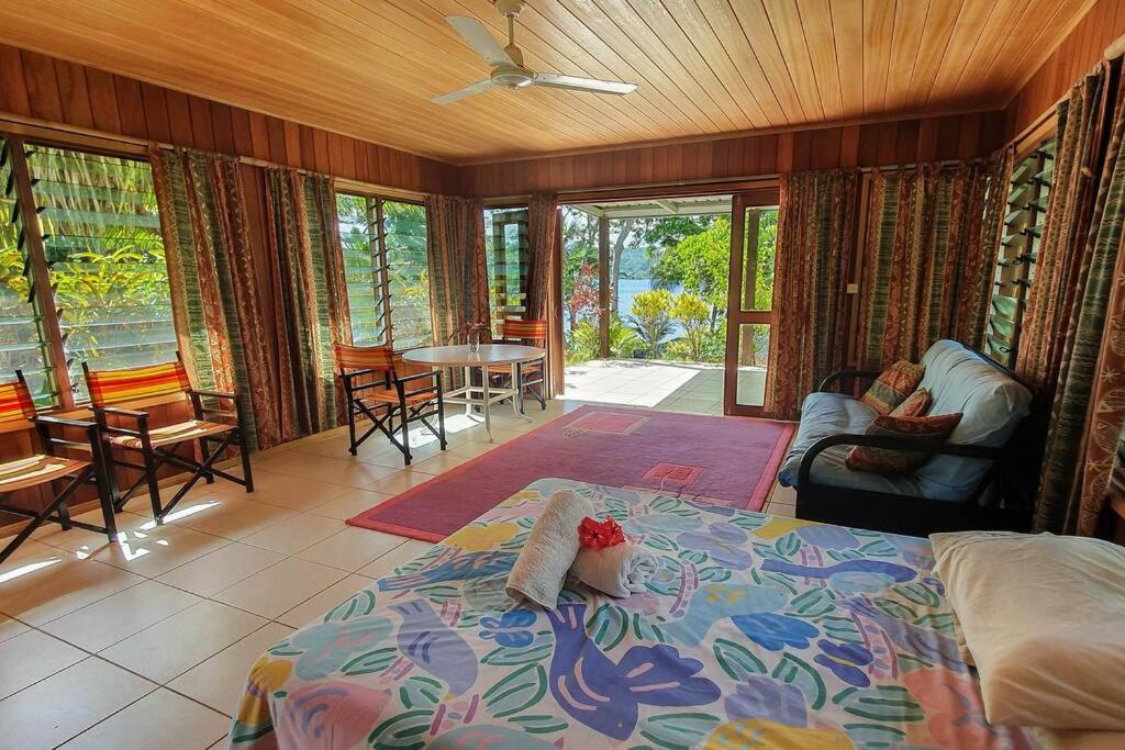 Aimbuei BayAore Hibiscus Retreat的卧室配有一张床和一张桌子及椅子