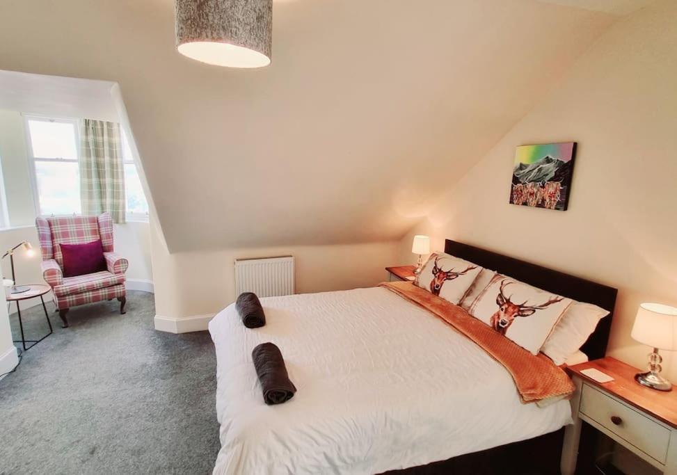 因弗内斯Highland Historical Home in Inverness City Centre的一间卧室配有一张床、一张桌子和一把椅子