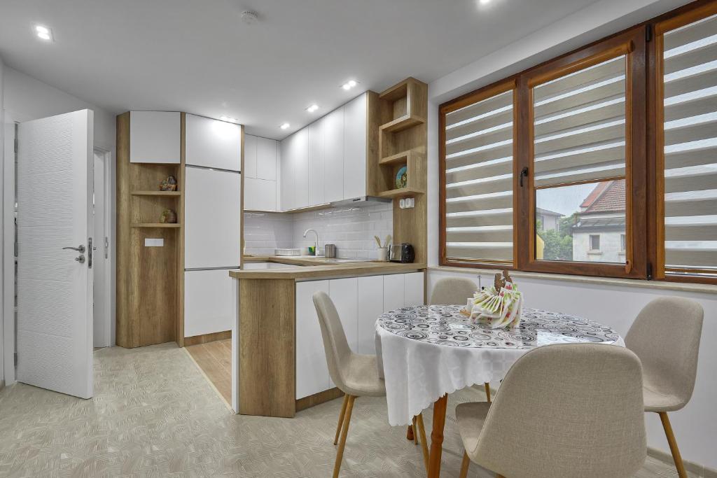 布尔加斯Weiss Estate by EstateAutomata的一间带桌椅的厨房和一间带白色橱柜的厨房