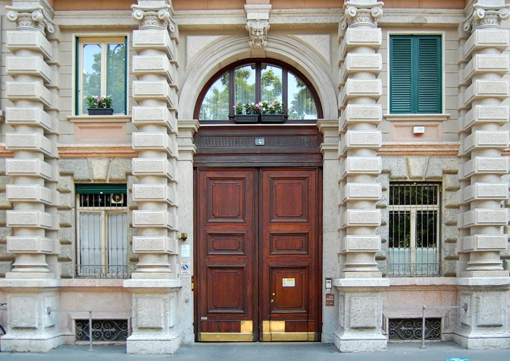 米兰Castello Guest House Milano的大楼内带2扇窗户的大型木门