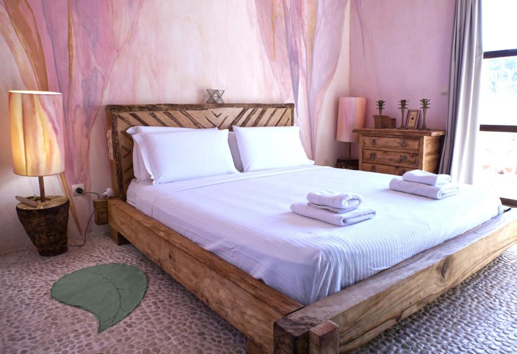 伊维萨镇Boutique Hostal La Curandera de Salinas的一间卧室配有一张带毛巾的木床