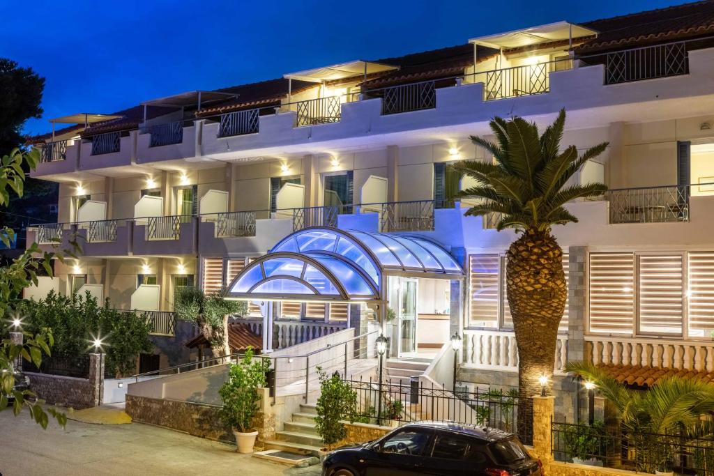 托隆Hotel Serenity Tolo的前面有棕榈树的建筑