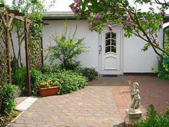 奥斯赛拜-屈隆斯博恩Ferienhaus in Kühlungsborn的房屋前带雕像的花园