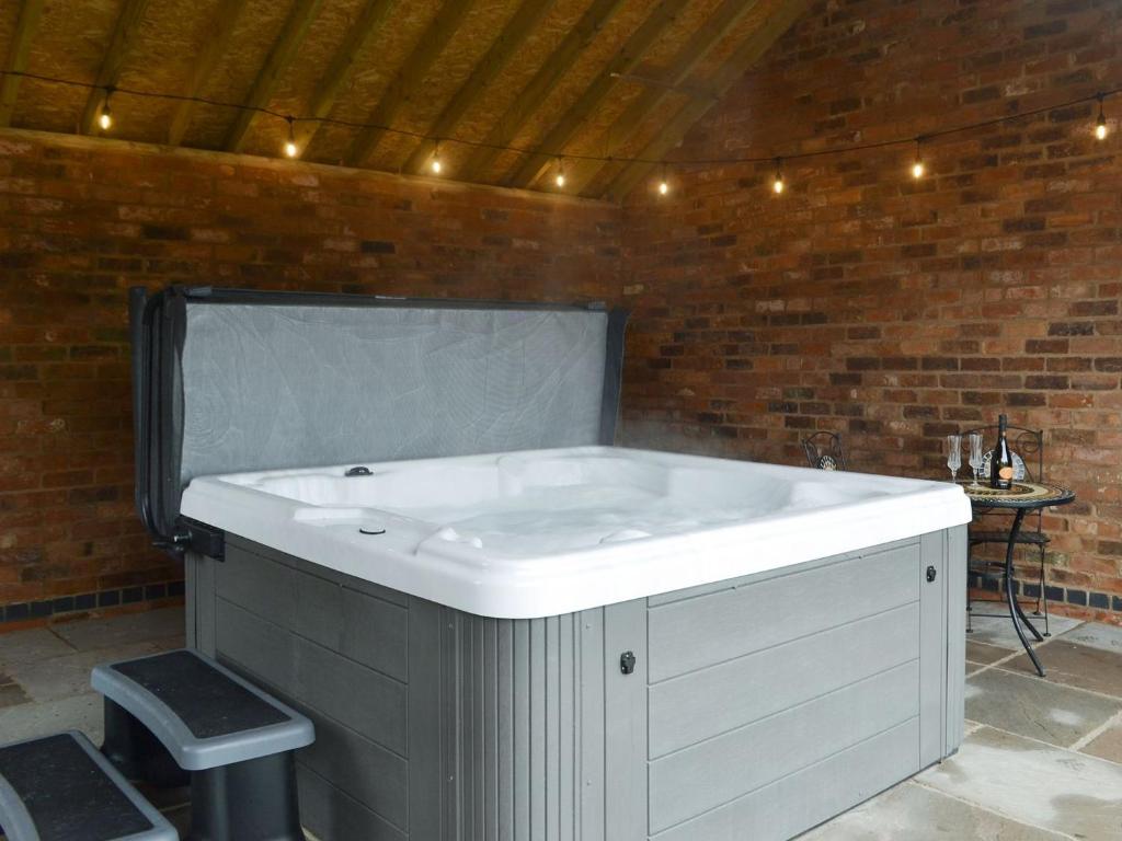 Barnby MoorCowslip - Uk13138的砖墙房间内的大白色浴缸