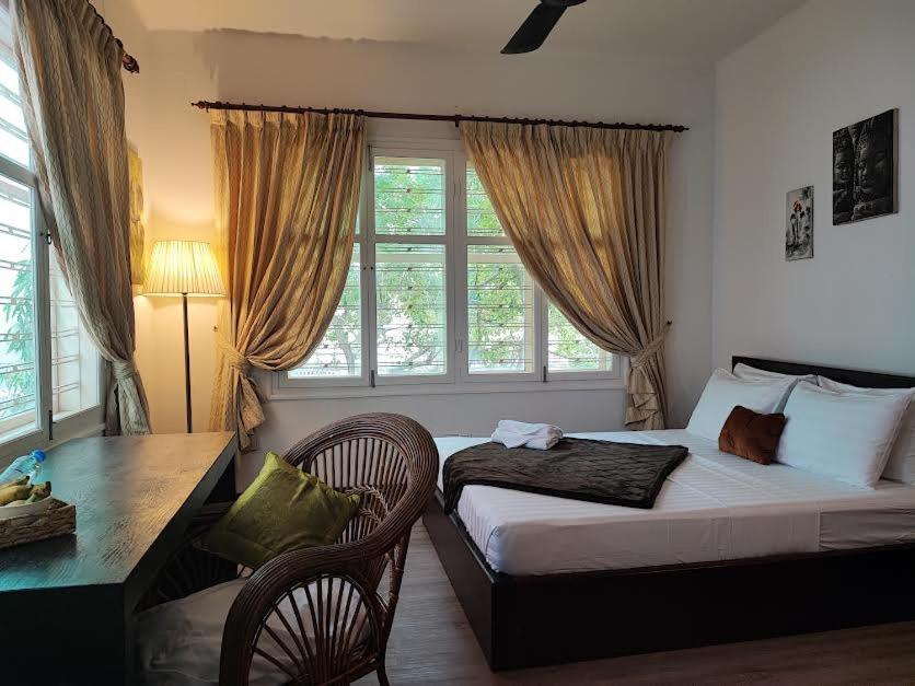 金边Villa Papillon的一间卧室配有一张床、一张书桌和一个窗户。