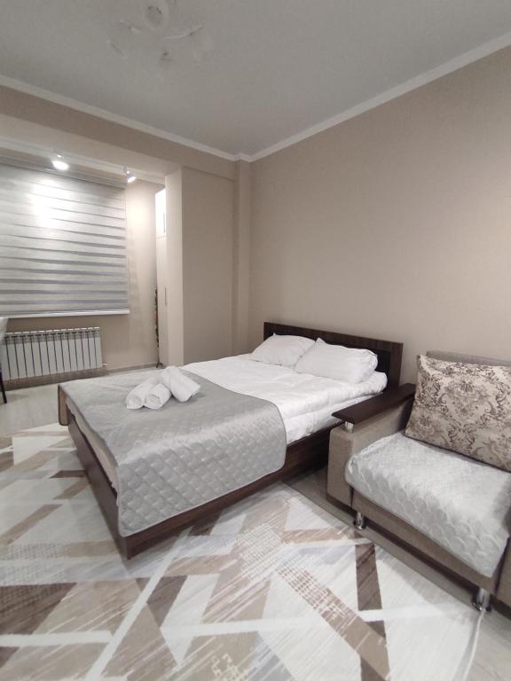 阿拉木图Уютная квартира-студия ЖК Lotus Terrace的一间带两张床和一张沙发的卧室