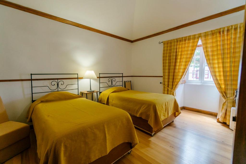 蓬塔德尔加达蒙特英格尔斯农家乐的一间卧室设有两张床、一张沙发和一个窗口
