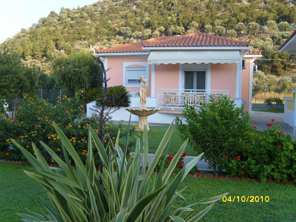 科尔维利Elisabeth Villas的一座粉红色的房子,在院子里设有喷泉