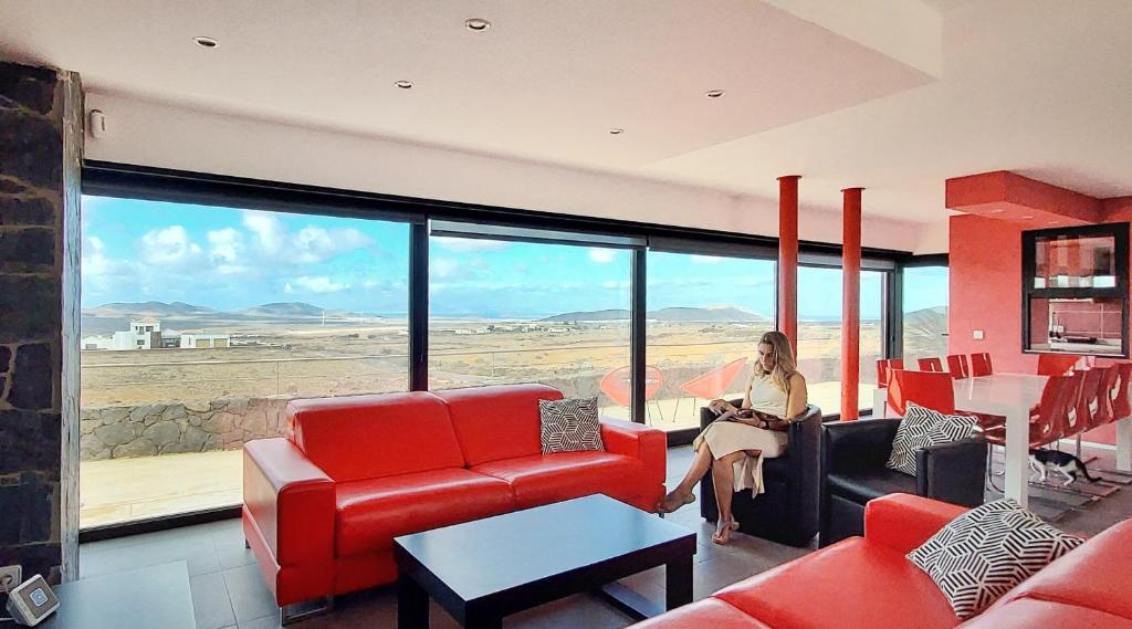 维拉韦德Luxury Villa Sand Volcano的坐在客厅里,欣赏沙漠景色的女人