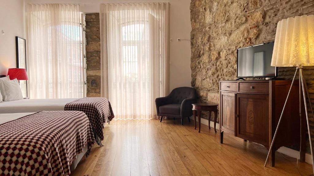 里斯本莎杜卡萨杜拜鲁旅馆的一间卧室配有一张床和一台平面电视