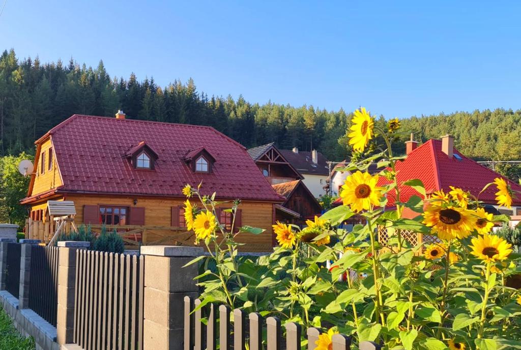 VažecHolidayhouse Chalupa Alžbetka的一座带围栏和向日葵的木屋