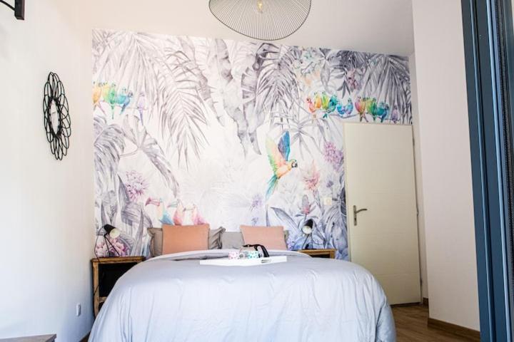 VinzellesChambre tropicale privée au coeur d'un village calme et proche du vignoble的一间卧室配有一张白色床和热带壁纸