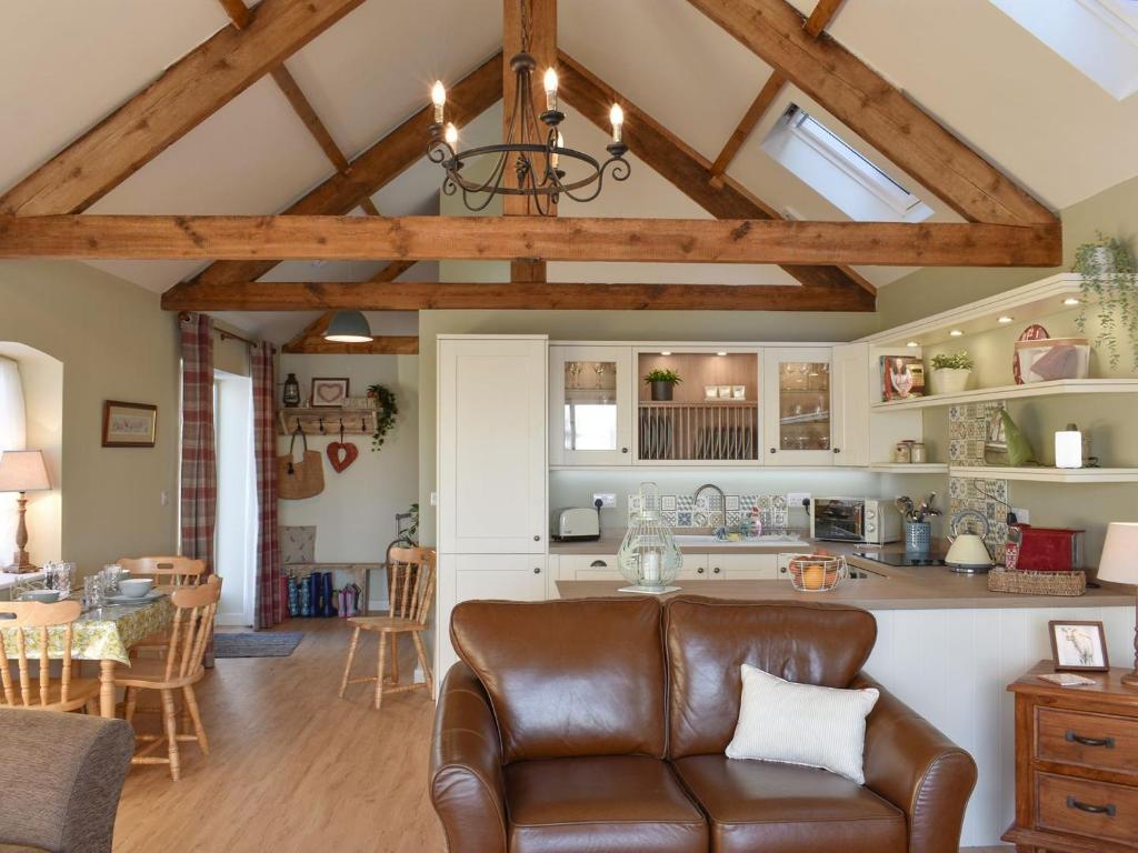 塞奇菲尔德Calf House Cottage的厨房以及带真皮沙发的客厅。