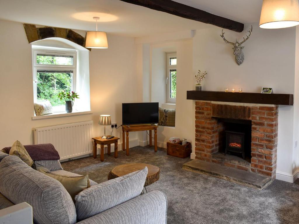 SilsdenBeckside Cottage的带沙发和壁炉的客厅