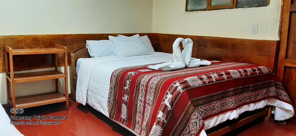 库斯科Hostal sambleño cusco Piero suite的一间卧室配有一张床,床上有毛巾