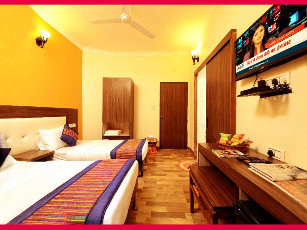 阿格拉Taj Haveli Agra - 5 Minute Walking Distance from Taj Mahal Agra的酒店客房配有两张床和一张书桌