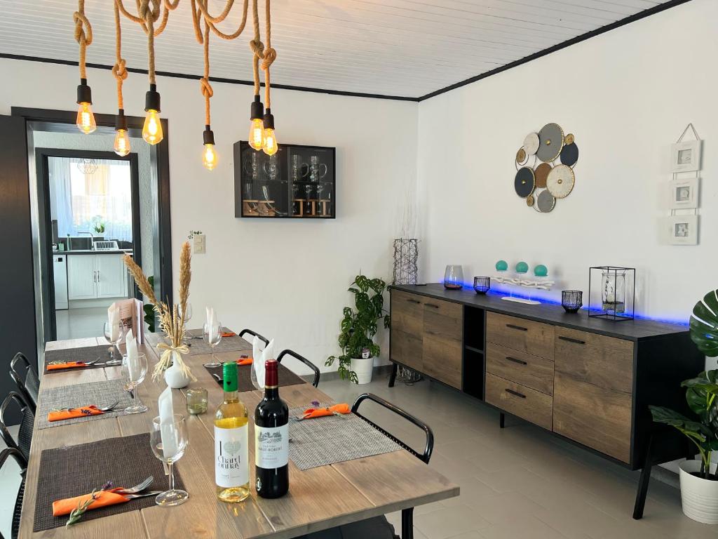 福维莱尔斯Le Clos fleuri的用餐室配有带葡萄酒瓶的桌子