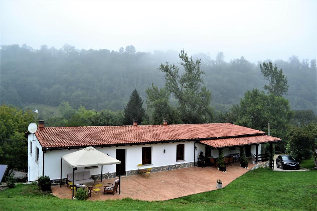 BeloncioFinca La Naguada Casa Rural en Asturias的白色的房子,前面有帐篷