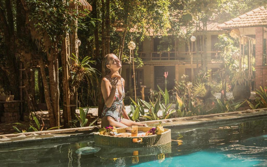 富国Valley Village Phu Quoc的坐在游泳池旁的女人