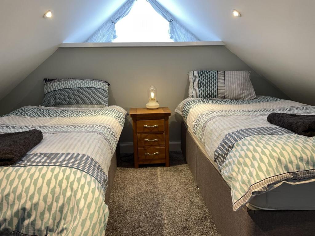 牛顿斯图尔特Galloway Farmstay Claunch的阁楼卧室设有两张单人床和一扇窗户。