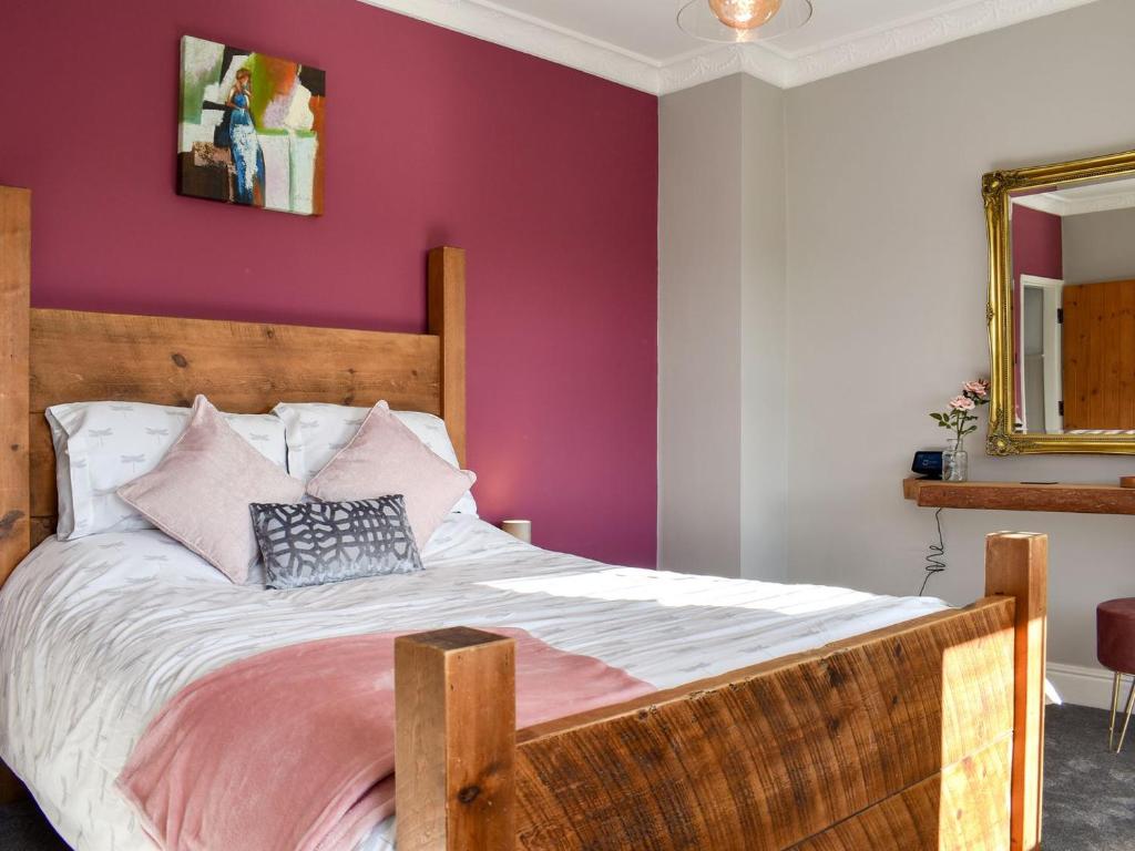 切斯特菲尔德Dark Lane的一间卧室配有一张带紫色墙壁的木床