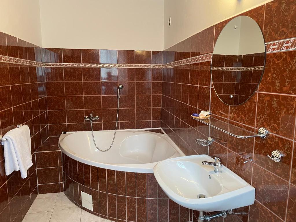 克拉托维Hotel Ennius的带浴缸、水槽和镜子的浴室