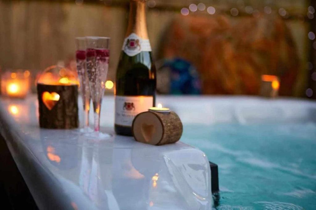 梅罗那瑞斯Entire Home Meloneras BBQ Jacuzzi PoolGolf的一瓶香槟和一张桌子上的蜡烛