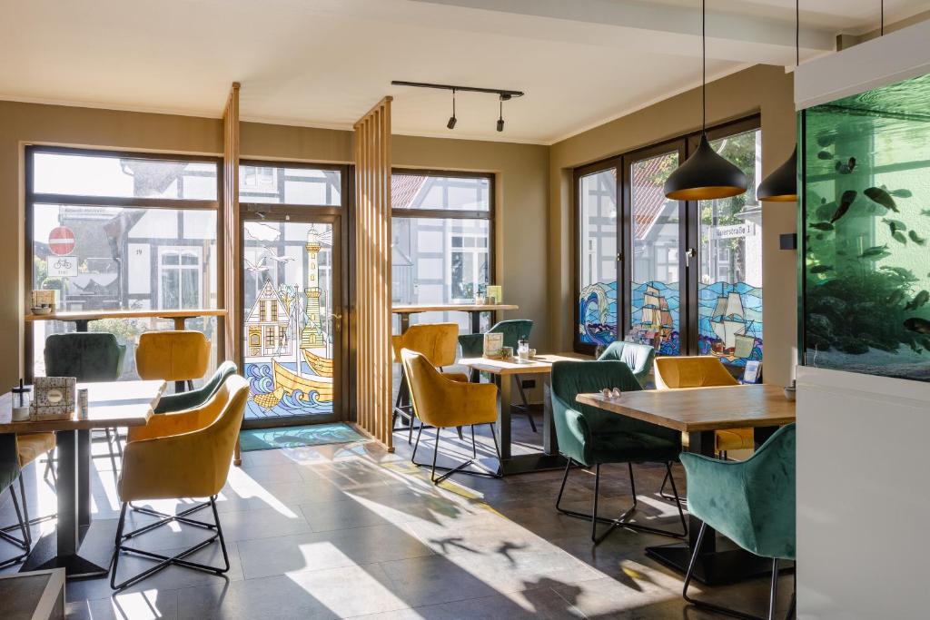 瓦尔内明德Alex & Rine - Pension Zum Alten Strom的餐厅设有桌椅和窗户。