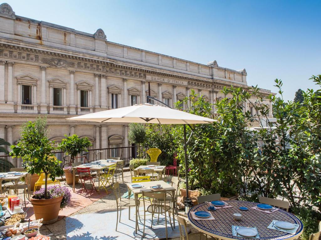 罗马萨洛托蒙蒂酒店的一个带桌椅和遮阳伞的庭院