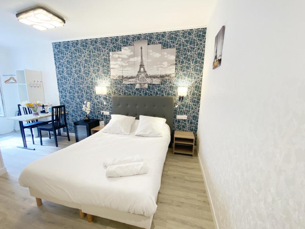巴黎阿维亚迪克酒店的卧室配有白色的床和蓝色的墙壁