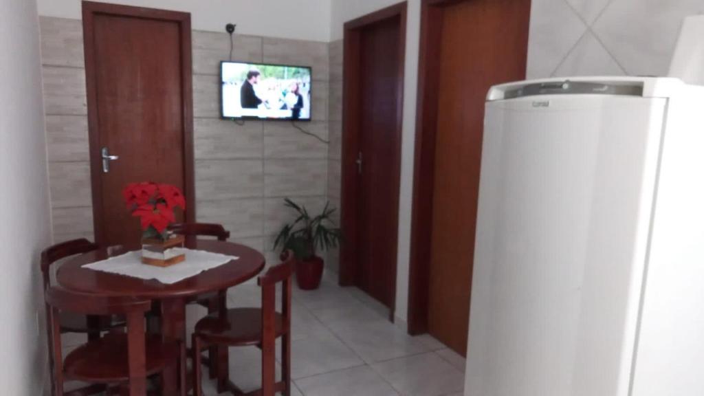 弗洛里亚诺波利斯Apartamento a poucos minutos do Aeroporto de Floripa e das Praias do Sul da Ilha的一间带桌椅和电视的用餐室
