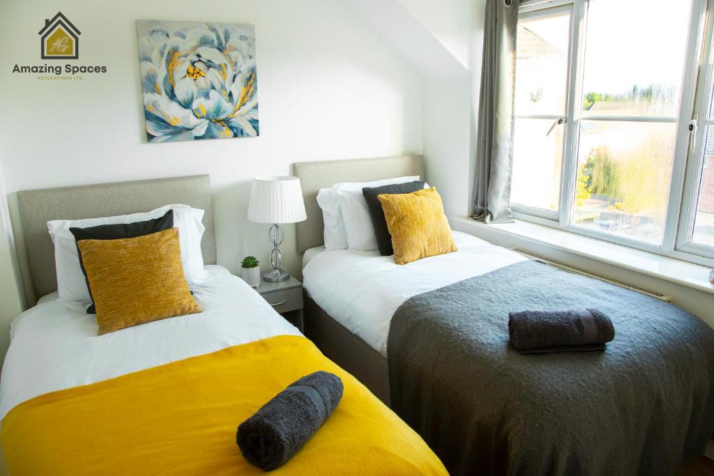 沃灵顿Cosy 2 Bed Flat Sleeps 4 with Free Parking by Amazing Spaces Relocations Ltd的卧室内两张并排的床