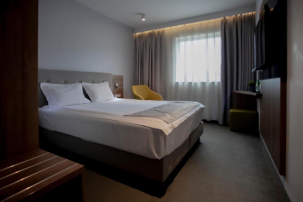 罗兹Abton Hotel的酒店客房设有床和窗户。