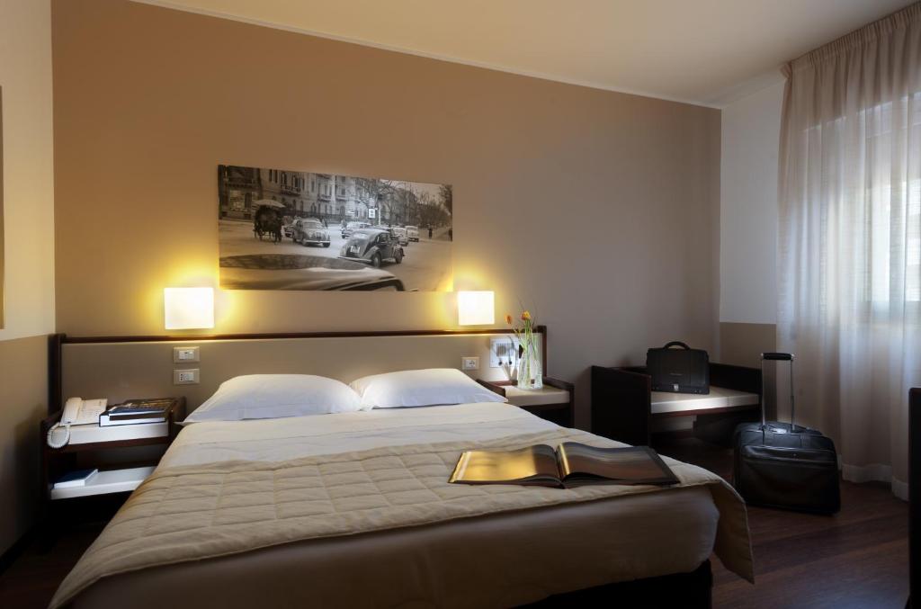 巴勒莫阿斯托瑞亚宫酒店的酒店客房设有一张大床,墙上挂有绘画作品
