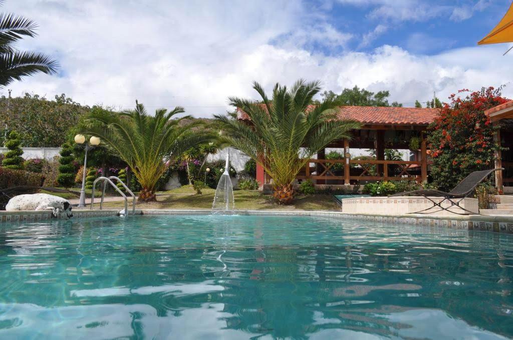 伊瓦拉Lujosa Quinta Vacacional Ibarra的一座房子前面带喷泉的游泳池