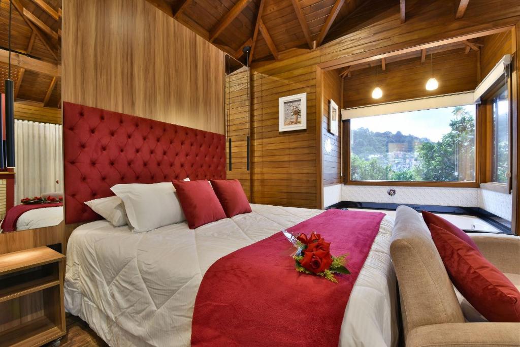 格拉玛多Stillo Gramado Dutra的一间卧室配有一张大床和红色床头板