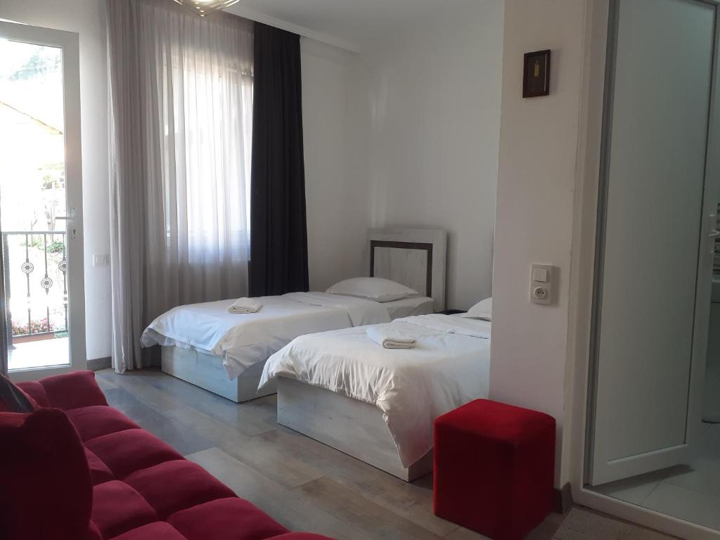 博尔若米Family house的酒店客房带两张床和一张红色沙发
