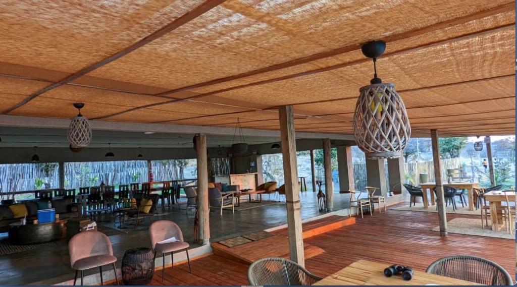 ChobeXhabe Safari Lodge Chobe的一间带桌椅和天花板的客厅