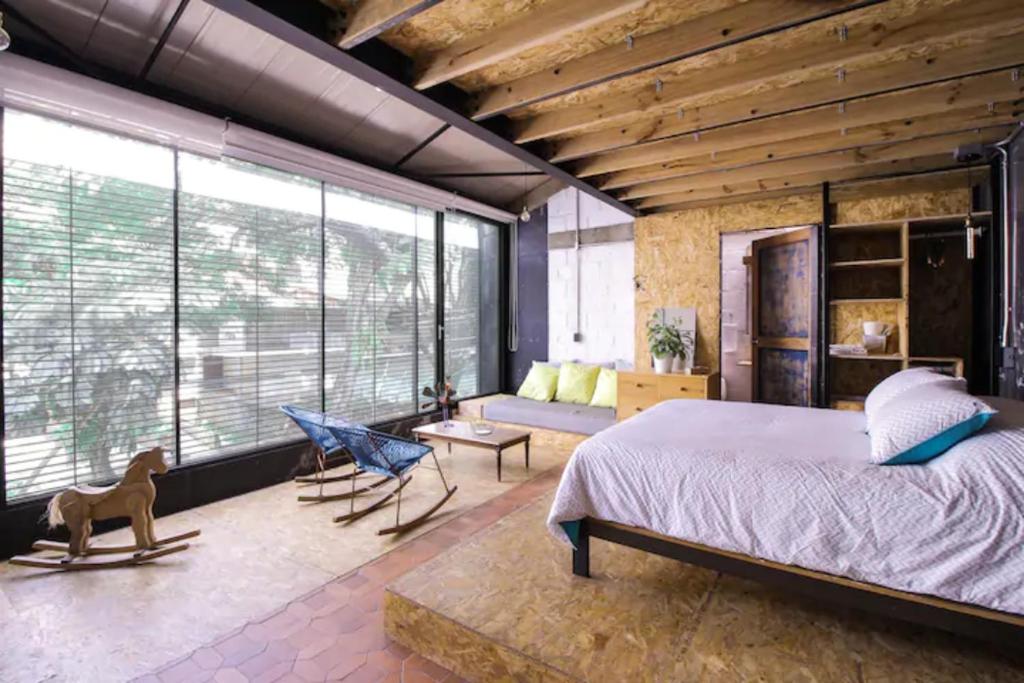 卡利Santa Teresita Loft的一间卧室设有一张大床和一个大窗户