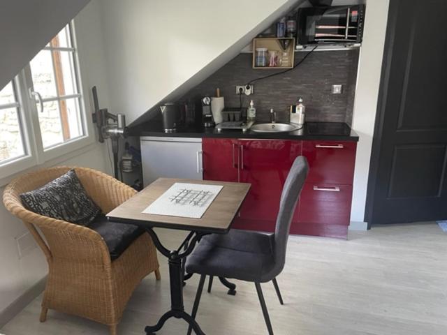 贡比涅Studio centre ville的厨房配有桌子、两把椅子和水槽