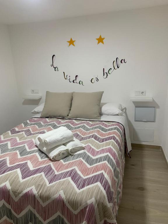 塞特尼尔La Vida es Bella的一间卧室配有一张床,上面有两条毛巾